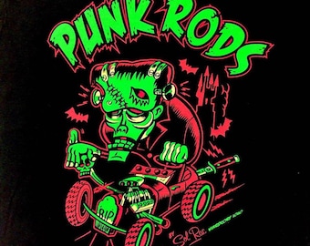 Peut inclure: Illustration verte et rouge d'un monstre de Frankenstein conduisant un hot rod avec les mots "Punk Rods" en lettres vertes au-dessus. Le texte "by Sol Rac" et "Hardcore 1980" sont également inclus dans l'image.