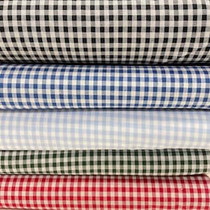 Könnte beinhalten: Fünf Rollen Gingham-Stoff in verschiedenen Farben: Schwarz-Weiß, Blau-Weiß, Hellblau-Weiß, Dunkelgrün-Weiß und Rot-Weiß.