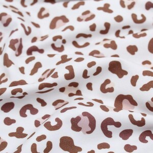 Nahaufnahme Jersey mit Leoparden Flecken in braun und rosa auf weißem Hintergrund