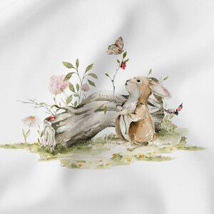 Peut inclure: Illustration &agrave; l'aquarelle d'un lapin brun regardant un papillon. Le lapin est pr&egrave;s d'une b&ucirc;che, de fleurs et de verdure. Une coccinelle est pos&eacute;e sur une marguerite. L'&oelig;uvre a une ambiance douce et fantaisiste.