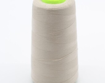 Peut inclure: Une grande bobine de fil à coudre beige enroulée en forme conique. Le fil est étroitement enroulé autour d'un noyau central, avec un capuchon en plastique vert néon vif sur le dessus. La bobine a une base plate et un profil cylindrique conique.