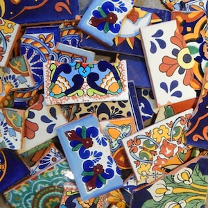 May include: A collection of colorful, hand-painted ceramic tile pieces with intricate floral designs in shades of blue, green, yellow, orange, and red. The tiles are broken into various shapes and sizes, creating a mosaic-like effect.