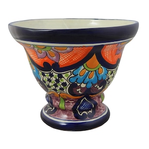 May include: A colorful ceramic vase with a wide, round opening and a flared base. The vase is decorated with intricate floral patterns in shades of blue, green, orange, and purple.