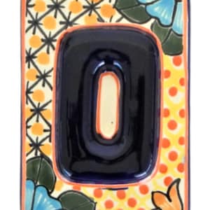 May include: A ceramic tile with a colorful floral design and a blue number "0" in the center. The tile is decorated with orange, yellow, and green accents.