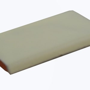 May include: A rectangular bar of white chocolate with a light brown layer underneath.