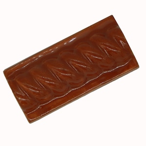 May include: A brown ceramic tile with a raised, rope-like design. The tile has a glossy finish.