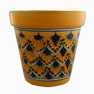 May include: A yellow terracotta flower pot with a blue and yellow geometric pattern. The pot is decorated with a repeating pattern of stylized peacock feathers.