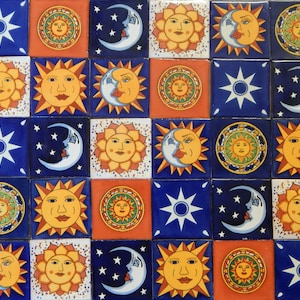 May include: A set of 16 colorful ceramic tiles featuring a repeating pattern of suns, moons, and stars. Each tile has a different design, with some featuring faces and others featuring geometric shapes. The tiles are all in shades of blue, yellow, orange, and white.