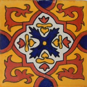 May include: A square tile with a colorful geometric pattern. The tile is decorated with red, yellow, blue, and white swirls and shapes. The center of the tile features a blue cross with a yellow center.