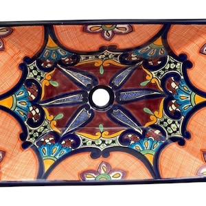 May include: Rectangular ceramic sink basin with a vibrant, intricate floral design. The basin features a central drain hole and is adorned with orange, blue, yellow, and burgundy patterns. The edges are outlined in a dark blue.