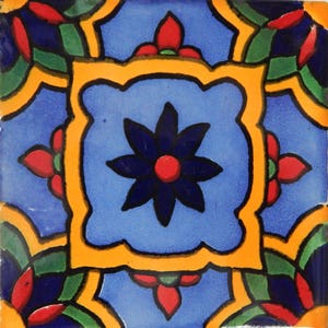 May include: A blue and yellow tile with a stylized floral design. The tile features a large, dark blue flower with a red center, surrounded by smaller red flowers. The tile is decorated with a yellow border and green accents.