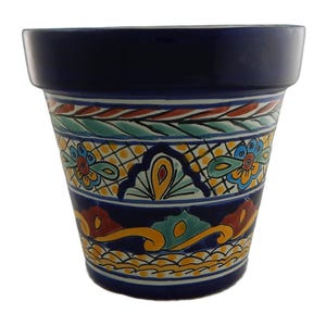 May include: A blue and white ceramic planter with colorful floral and geometric designs. The planter has a wide rim and a rounded base.