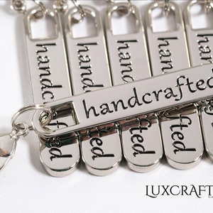 Puede incluir: Llaveros de plata con un cierre de langosta de plata. Cada llavero tiene una etiqueta de plata con la palabra "handcrafted" grabada.