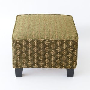 May include: A green and gold patterned square ottoman with black legs.
