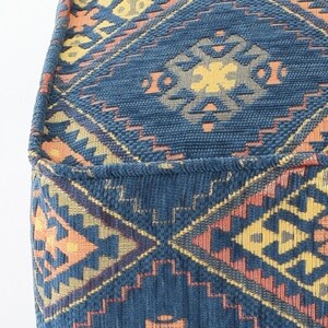 May include: A blue and orange patterned fabric ottoman with a geometric design. The fabric has a woven texture.