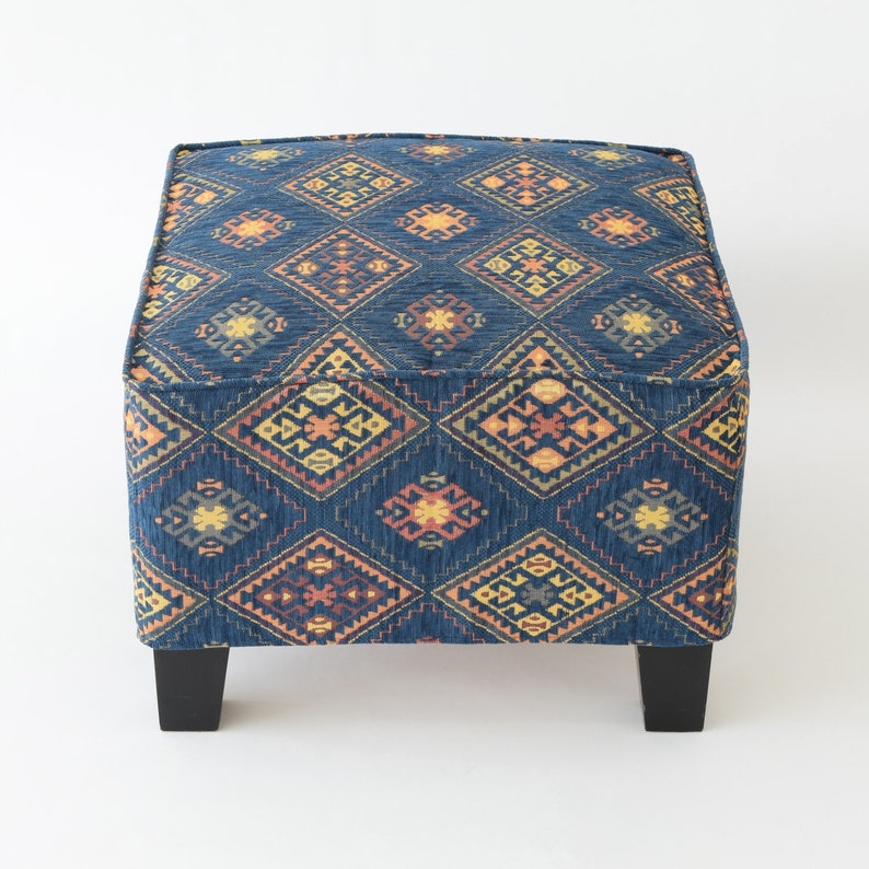 May include: A blue and orange patterned ottoman with black legs. The ottoman has a square top and a geometric design.
