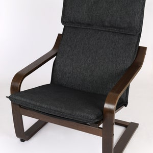 May include: A dark gray upholstered armchair with a wooden frame and a curved base. The chair has a high back and a comfortable seat.