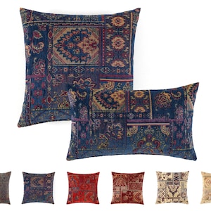 Könnte beinhalten: Zwei dekorative Zierkissen mit Patchwork-Design. Die Kissen haben einen marineblauen Hintergrund mit komplizierten Mustern in Rot-, Gold- und Lilatönen. Die Kissen sind quadratisch und rechteckig und haben eine strukturierte Optik.