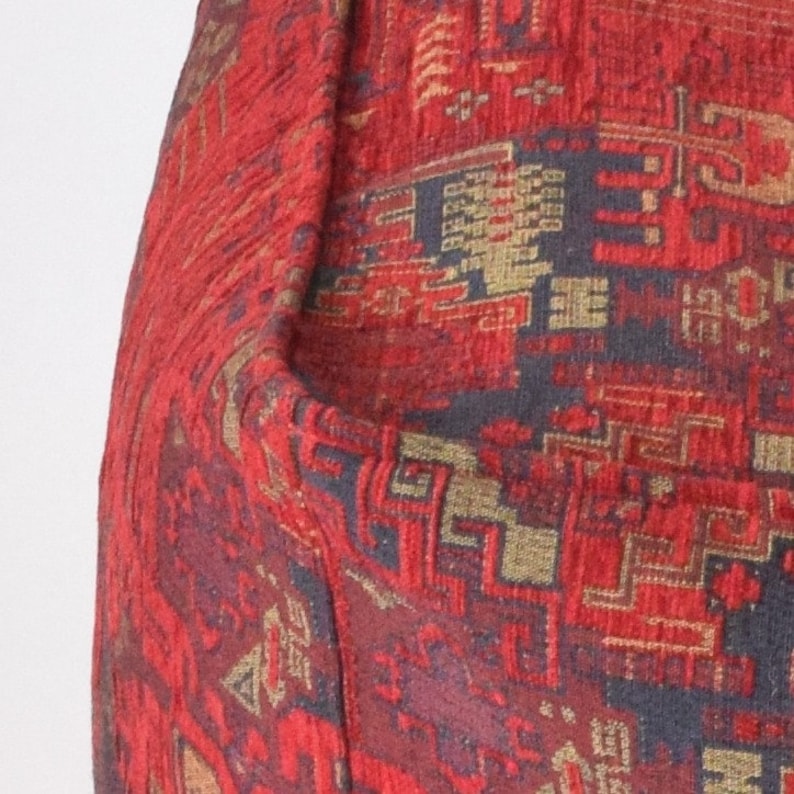 Pu&ograve; includere: Tessuto rosso con un motivo tessuto di forme geometriche in oro, nero e rosso.