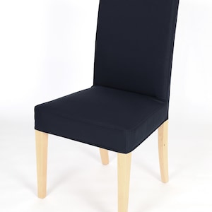 May include: A dark blue dining chair with a wooden frame. The chair has a simple design and is upholstered in a dark blue fabric.
