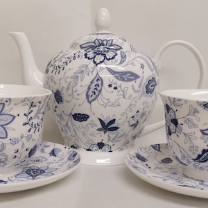 May include: A blue and white floral tea set with a teapot, two cups, and two saucers.