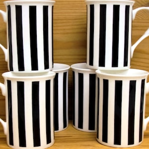 May include: Set of six black and white striped ceramic mugs. The mugs feature a classic design with vertical black stripes on a white background.