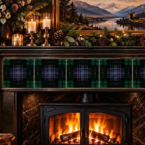 May include: A row of five square decorative tiles featuring a dark green, black, and blue plaid tartan pattern. The tiles are arranged horizontally across the front of a dark wood fireplace mantel above a burning fire with visible flames.