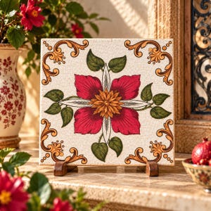 May include: A square ceramic tile with a crackled off-white finish featuring a central floral design with deep red petals and a yellow centre, surrounded by green leaves and ornate golden-brown scrollwork in each of the four corners.