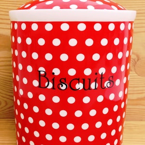 May include: Red and white polka dot ceramic biscuit jar with a white lid and the word "Biscuits" written in black.