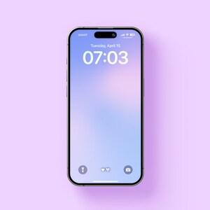 May include: A smartphone with a light blue and purple gradient background on the screen. The time is 07:03 and the date is Tuesday, April 15. The phone has a black frame and a white home button with three icons.