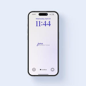 Op de afbeelding: Een smartphonescherm toont de tijd 11:44 uur en de datum woensdag 23 april. Het scherm toont de tekst "june moonstone" in een scriptlettertype, met pictogrammen onderaan.