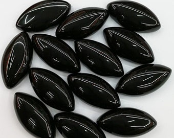 Op de afbeelding: Een verzameling van 15 zwarte, ovale edelsteen cabochons. De stenen zijn glad en gepolijst, met een glanzende afwerking.
