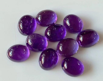 May include: A group of ten oval-shaped amethyst gemstones, each with a smooth, polished surface and a deep purple hue.