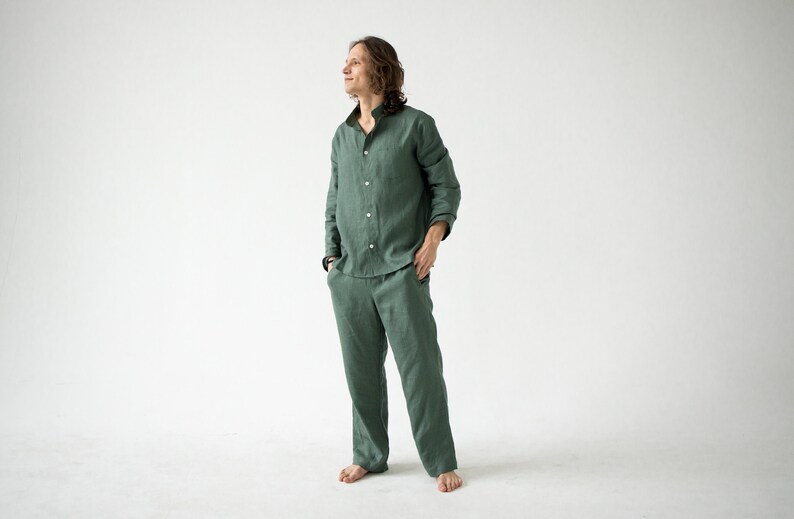 May include: A green linen pajama set. The set includes a long-sleeved button-down shirt and matching pants. The shirt has a mandarin collar and the pants have pockets. The fabric appears to be lightweight and breathable.