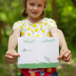Peut inclure: Un enfant tient ouvert un petit livre blanc avec des accents verts. Le livre a deux pages, l'une intitul&eacute;e "Un oiseau" et l'autre intitul&eacute;e "Chenille". Les pages sont blanches &agrave; l'exception de dessins simples d'un oiseau et d'une chenille.
