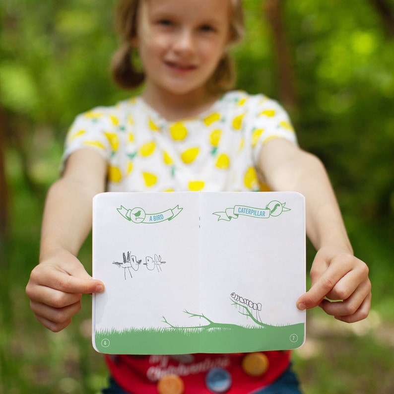Peut inclure: Un enfant tient ouvert un petit livre blanc avec des accents verts. Le livre a deux pages, l'une intitul&eacute;e "Un oiseau" et l'autre intitul&eacute;e "Chenille". Les pages sont blanches &agrave; l'exception de dessins simples d'un oiseau et d'une chenille.