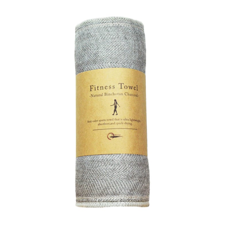 May include: A rolled up gray fitness towel with a brown label that reads "Fitness Towel - Natural Binchotan Charcoal - Anti-odor sports towel that is ultra lightweight, absorbent, and quick-drying."
