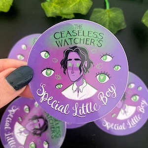 May include: Circular purple sticker with the text "THE CEASELESS WATCHER'S Special Little Boy". The sticker features a cartoon illustration of a person with green eyes and multiple green eyes around the image.
