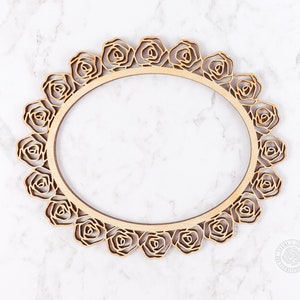 May include: A wooden oval frame with a decorative rose design. The frame is made of natural wood and has a rustic look.
