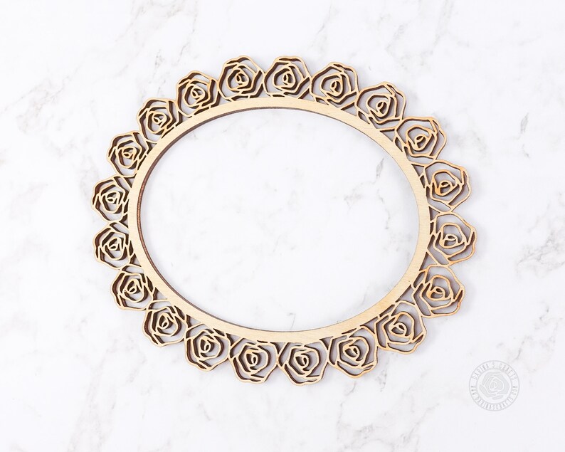 May include: A wooden round frame with a decorative rose design. The frame is made of natural wood and has a smooth finish.