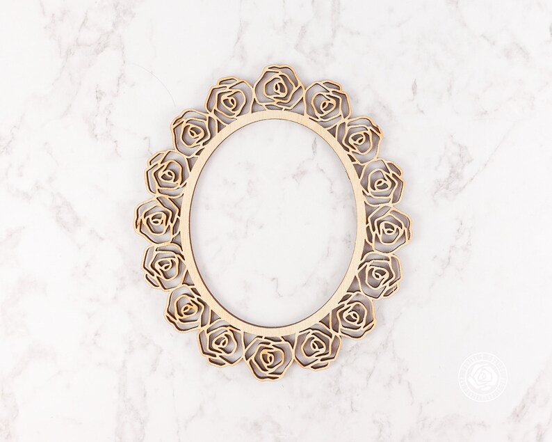 May include: A wooden frame with a decorative rose design. The frame is oval shaped and has a natural wood finish.