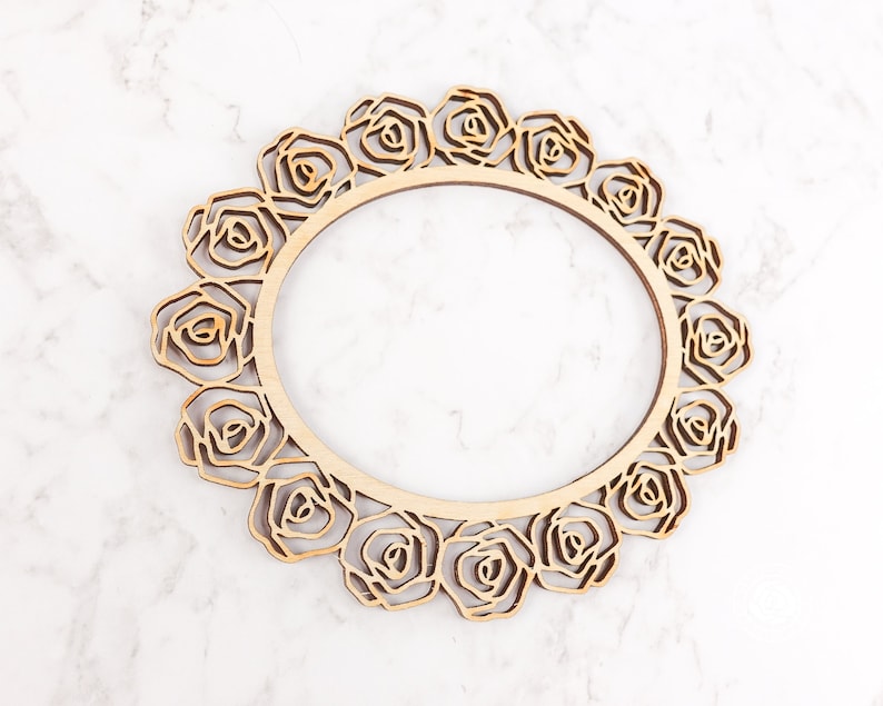 May include: A wooden frame with a circular cutout and a decorative design of roses around the edge.