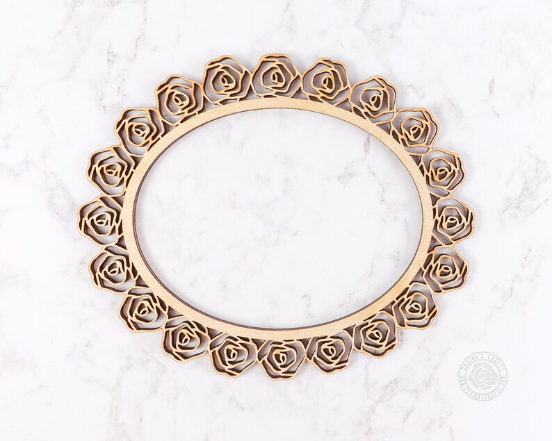 May include: A wooden oval frame with a decorative rose design. The frame is made of natural wood and has a rustic look.