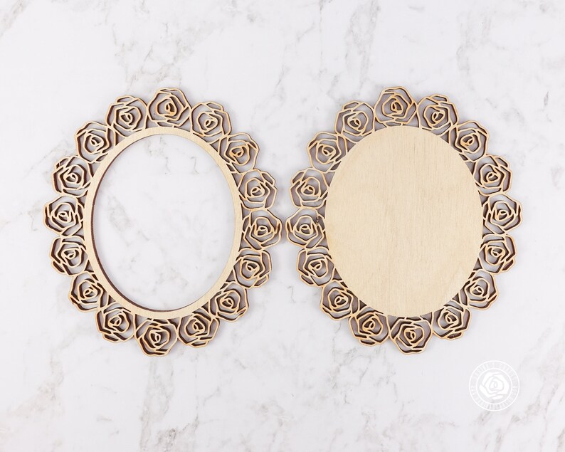 May include: Two unfinished wooden oval frames with a decorative rose design. The frames are made of wood and have a natural finish.