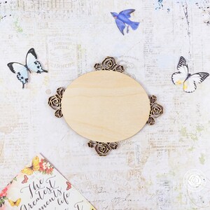 May include: A wooden oval-shaped sign with a decorative floral design. The sign is blank and ready to be personalized.