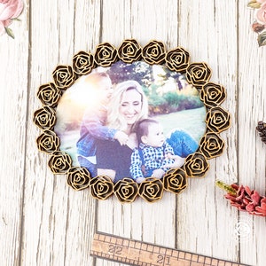 May include: A wooden picture frame with a rose design, featuring a photo of a mother and her two children. The frame is a light brown colour and has a circular shape.
