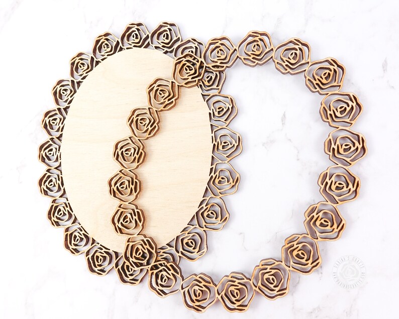 May include: Two wooden oval-shaped plaques with a decorative rose pattern. The plaques are layered on top of each other, creating a three-dimensional effect.