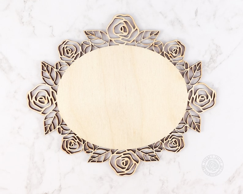 May include: A wooden round plaque with a decorative floral design. The design features a circle of roses and leaves.