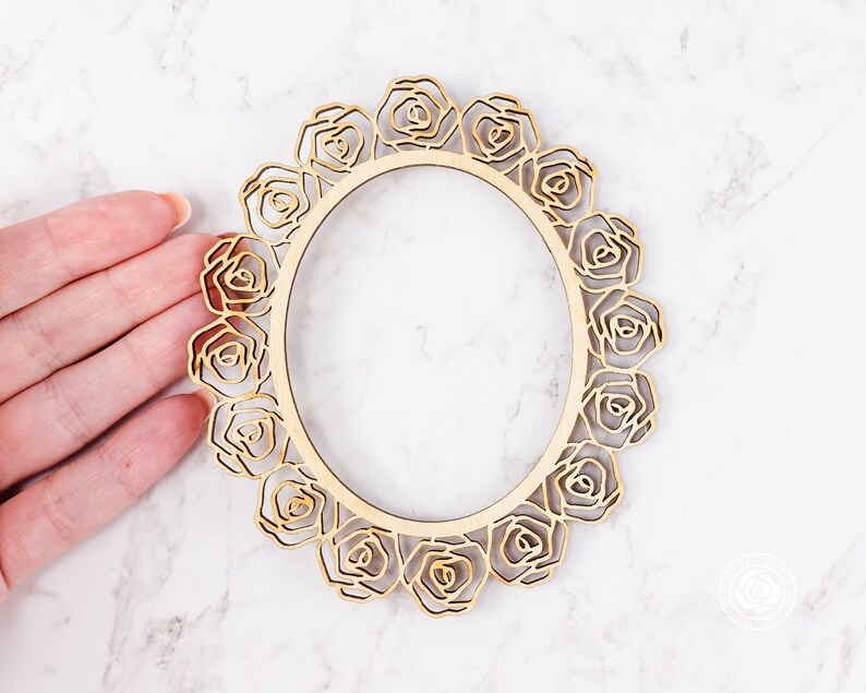May include: A wooden frame with a decorative design of roses around the edge. The frame is unfinished and ready to be painted or stained.
