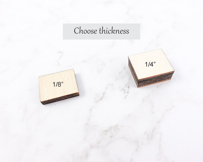 May include: Two small, square wooden blocks with the text "1/8" and "1/4" printed on them. The blocks are light-colored with dark brown edges. The text "Choose thickness" is above the blocks.
